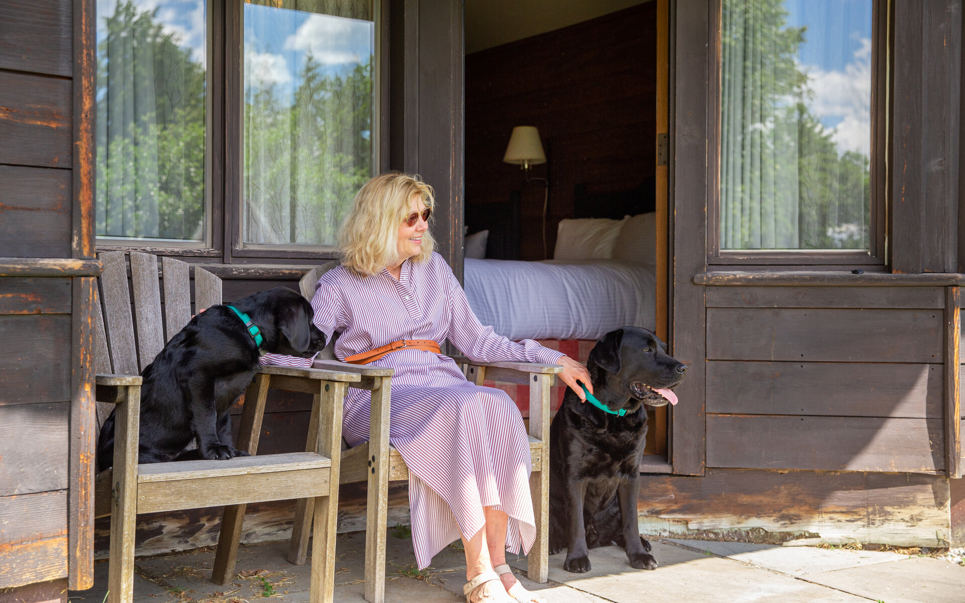 woman sitting with dogs at our pet friendly Stowe resort